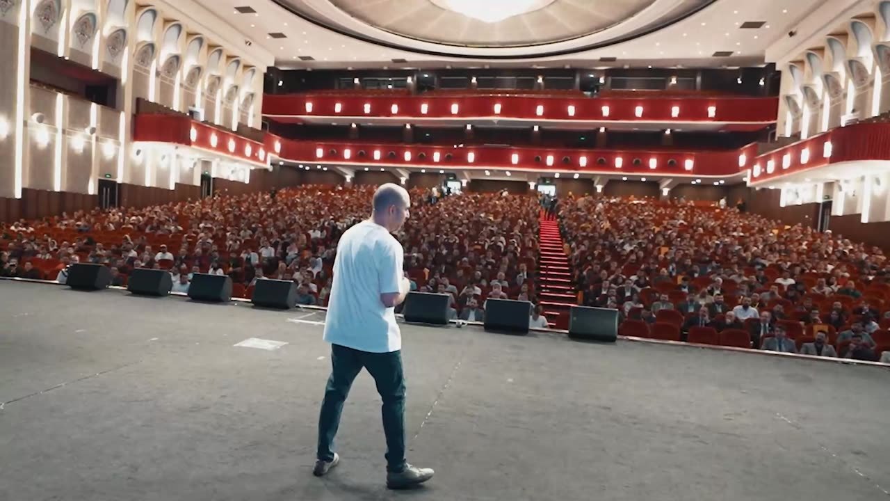 سخنران روی صحنه بیزینس سامیت ۲۰۲۵ رو به سالن پر هتل اسپیناس پالاس